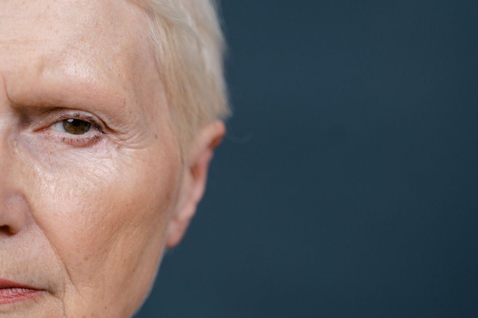 Close do rosto de uma mulher madura mostrando linhas de expressão ao redor dos olhos