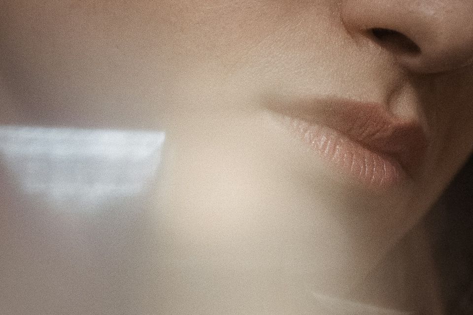 Detalhe suave do rosto de uma mulher, com luz difusa sobre a pele